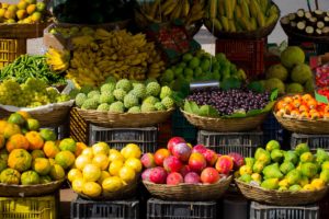 Fresh fruits at a grocery store, that can help you answer how to find vegan food for travel