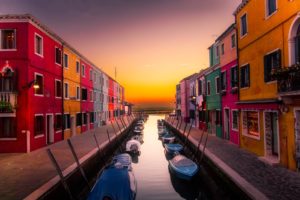 Colorful buildings and boats at sunset